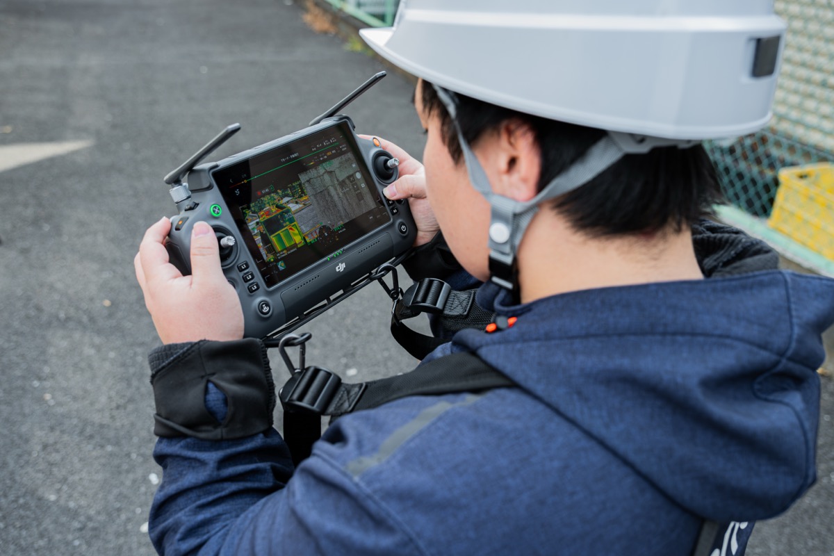 受講生がDJI送信機を操作してドローンを精密制御している様子